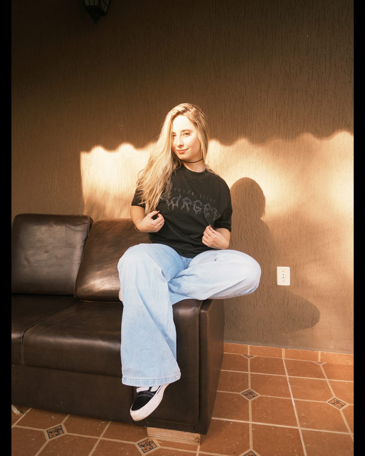 Modelo vestindo camiseta TWRGET Absurdedition sob luz dourada